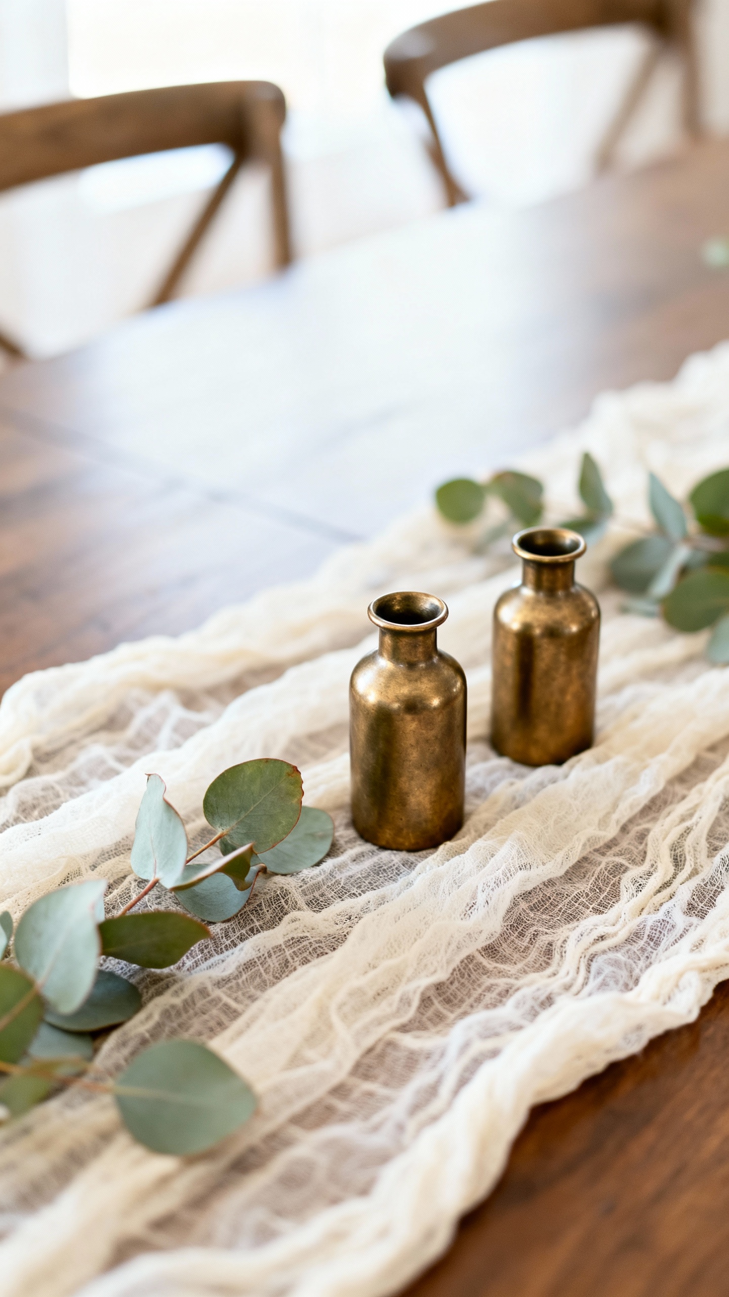 Gauze table runner with eucalyptus, three bud vases, brushed brass