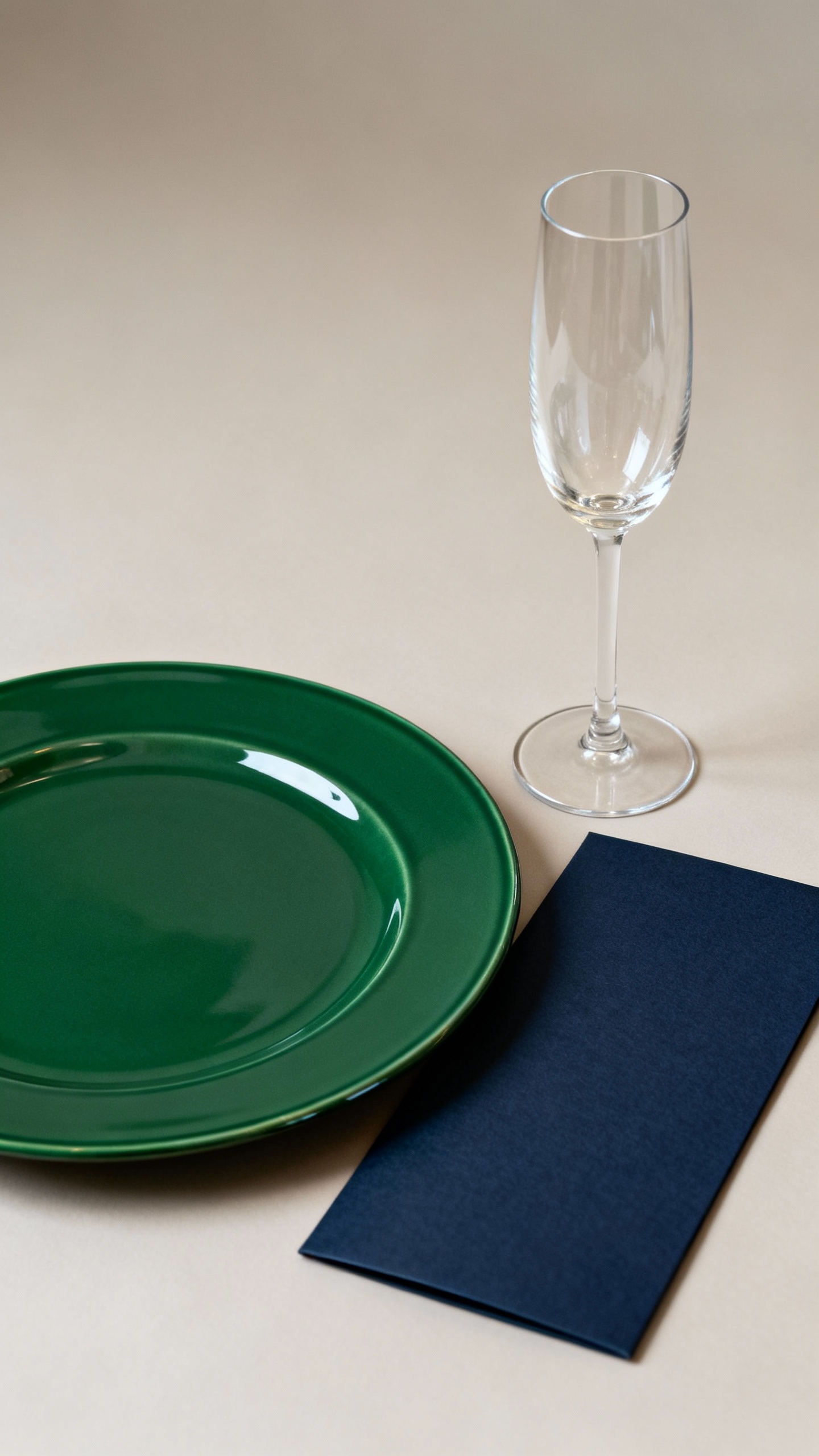 Navy menu beside champagne flute on emerald charger plate