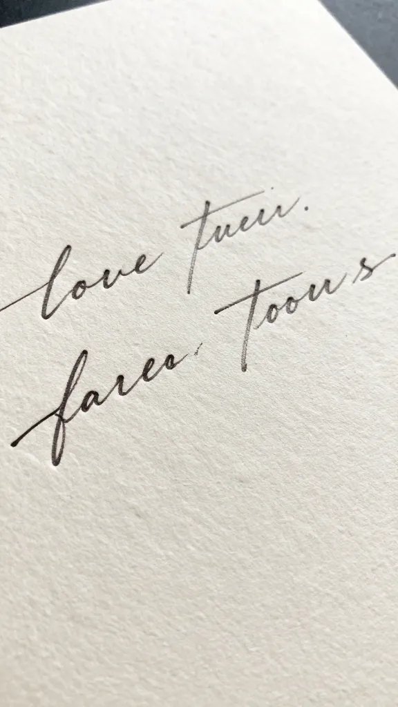 closeup of a textured ivory invitation with handwritten script