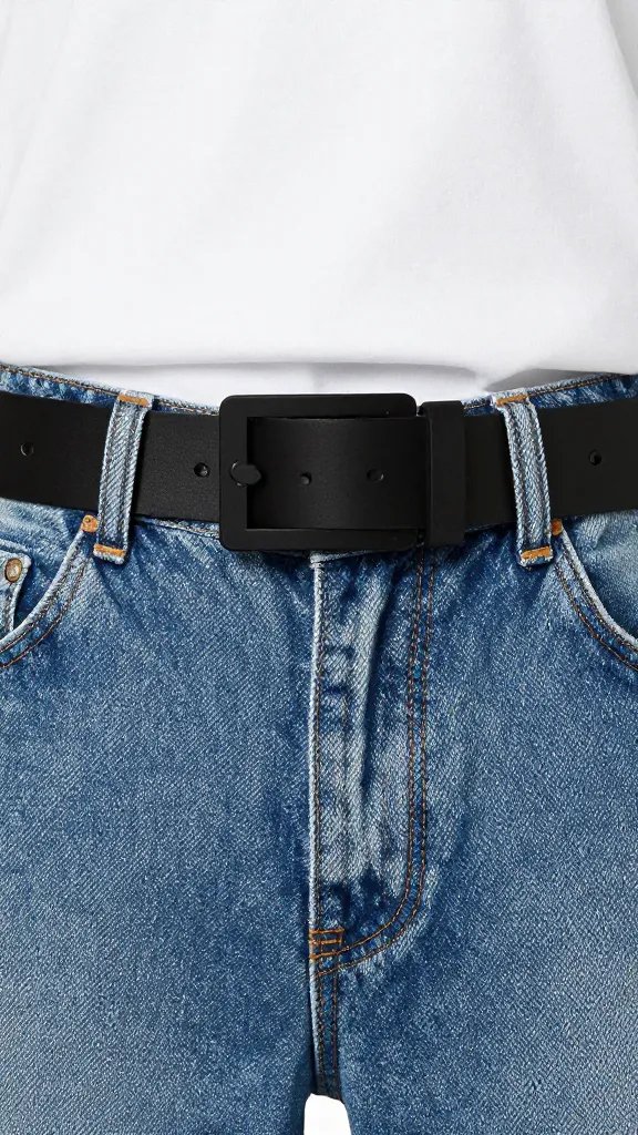 Closeup of a denim jeans and white tee silhouette with bold statement belt