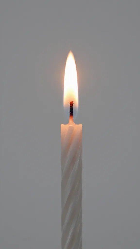 closeup of a single birthday candle flame with soft bokeh